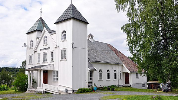 Hus med to tårn og to kors på taket. Grøntareal